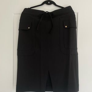 Tags on black stretch jersey pencil skirt. British brand Me&Em. Size 12 CDN.